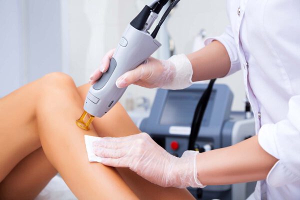 Lasergerät wird auf Bein einer Patientin gehalten - Lasermedizin_Dr. Daniela Hoffmann Hautarzt München-Schwabing